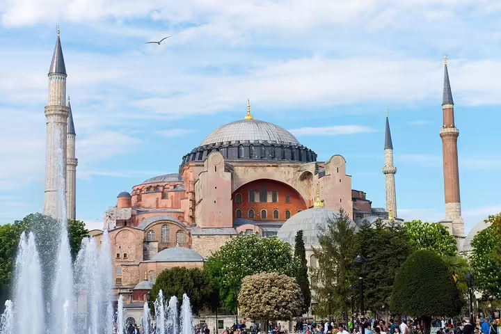 Hagia Sophia with vibrant gardens and fountains under a clear blue sky on a private Istanbul sightseeing tour.