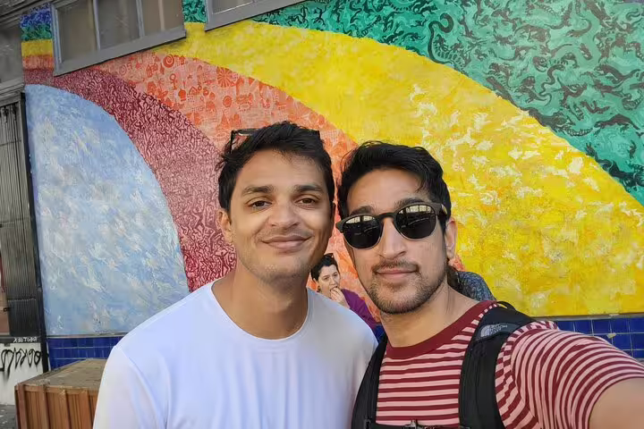 Two men smiling in front of colorful street mural in Haight-Ashbury San Francisco