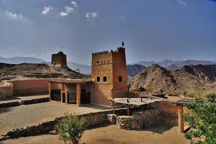 Historic fortresses nestled in the arid landscape of the Hajar Mountains, part of the Six Emirates tour from Dubai.