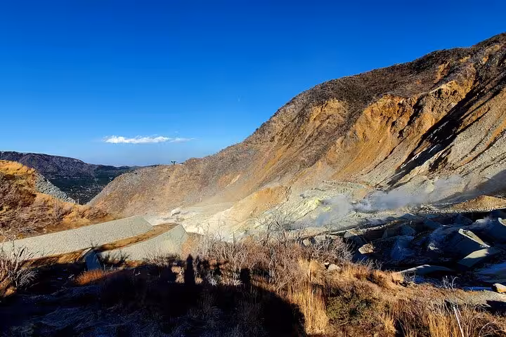 Hakone Owakudani volcanic valley with steaming sulfur vents and rugged mountain terrain on a clear day
