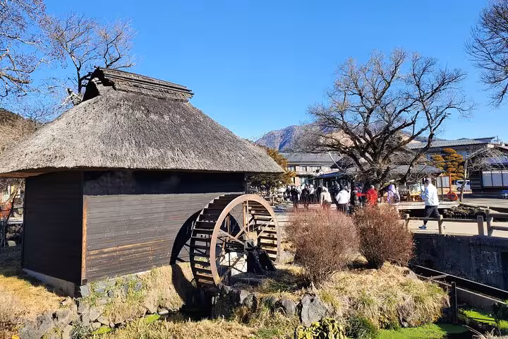 Traditional thatched-roof watermill in Hakone open-air museum on a 2-day Tokyo Mt Fuji tour