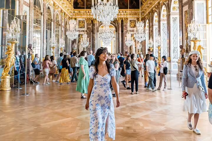 Visitors exploring the opulent Hall of Mirrors at Versailles, a highlight of the Paris to Versailles guided tour.