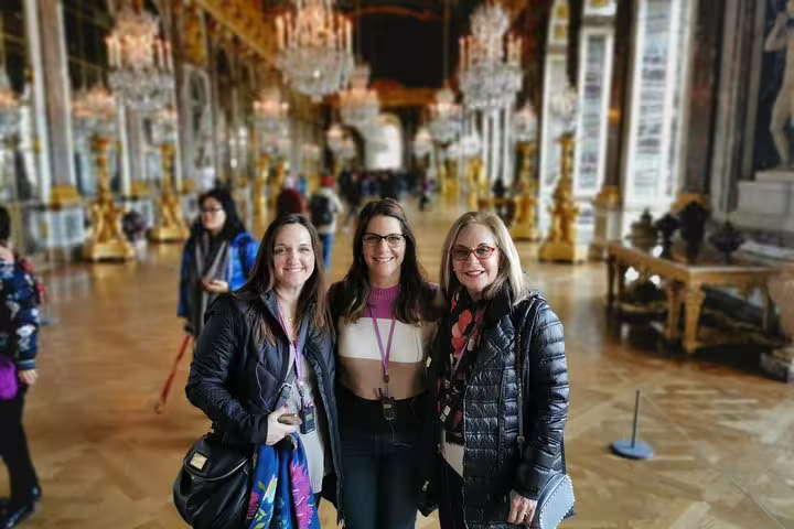 Visitors posing in the Hall of Mirrors during Versailles guided tour from Le Havre shore excursion