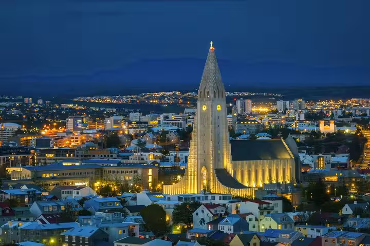 Hallgrímskirkja church illuminated at night overlooking the colorful city lights of Reykjavik, Iceland