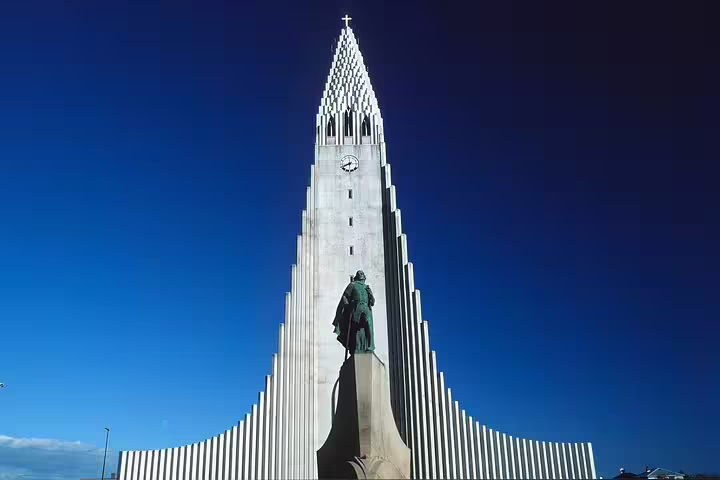 Hallgrímskirkja church tower with Leif Erikson statue in Reykjavik against blue sky