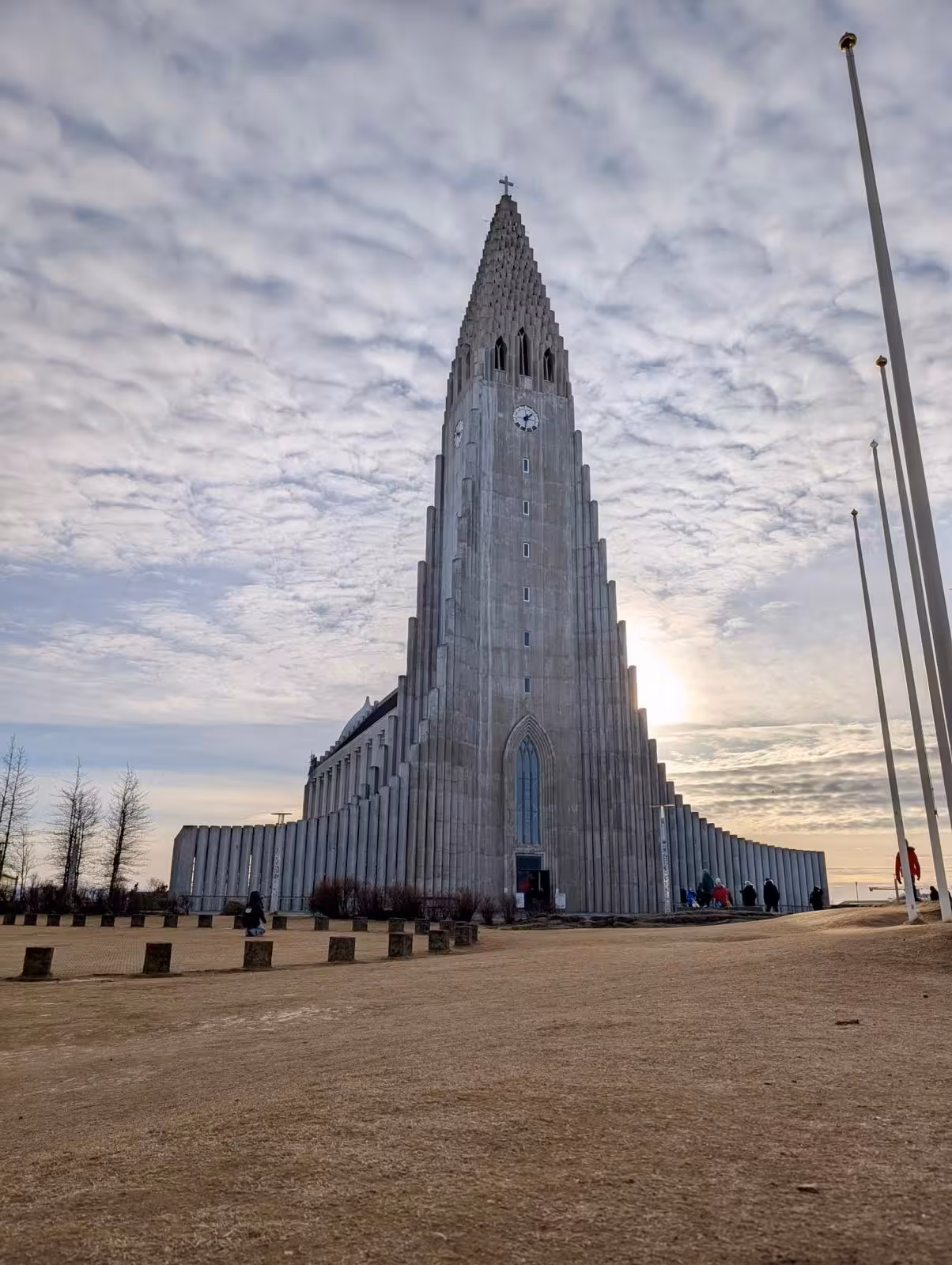 Hallgrímskirkja church towering against cloudy sky in Reykjavik Iceland with visitors at entrance