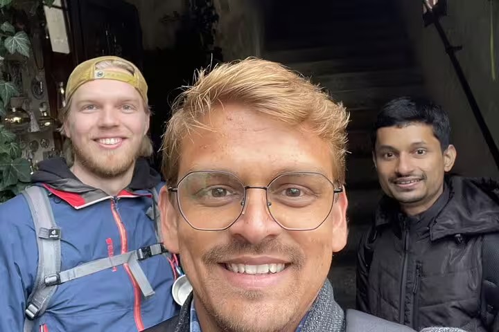 Three smiling men posing for a selfie during a guided outdoor tour in Hallstatt
