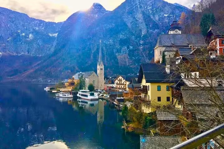 Scenic Hallstatt lakeside with boats and alpine peaks, private Salzburg Hallstatt and Melk day trip