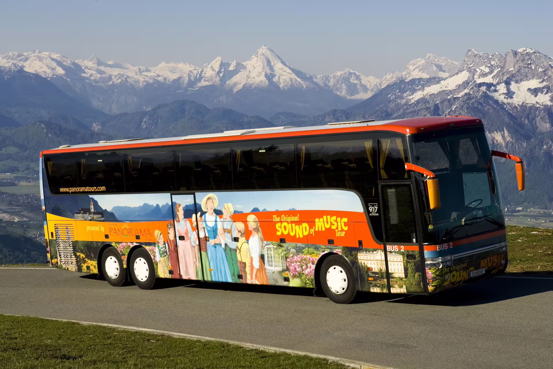 Vibrant Sound of Music tour bus against stunning alpine backdrop, highlighting the Hallstatt and Sound of Music experience.