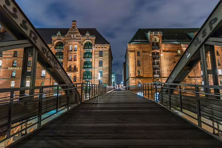Illuminated Speicherstadt warehouses seen from a footbridge, perfect stop on Hamburg e-scavenger hunt route