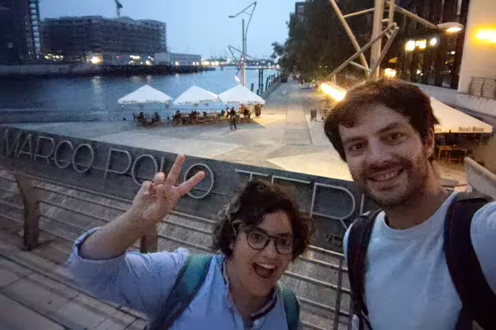 Two tourists smiling at Marco Polo Terrace Hamburg waterfront at dusk