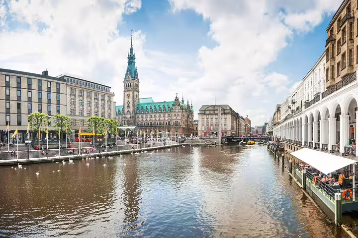 Hamburg Rathaus town hall reflected in Alster canal waterfront with arched colonnades