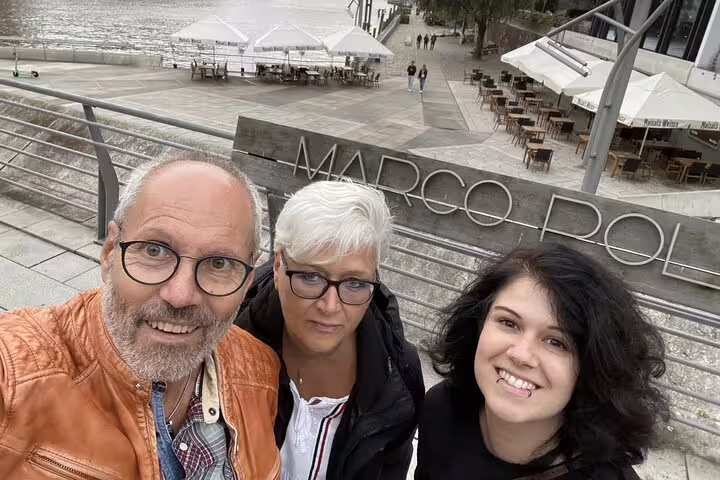 Three smiling tourists taking a selfie at Marco Polo waterfront area in Hamburg