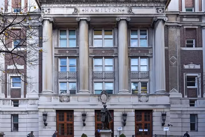 Hamilton building facade with Corinthian columns and bronze statue in Lower Manhattan NYC