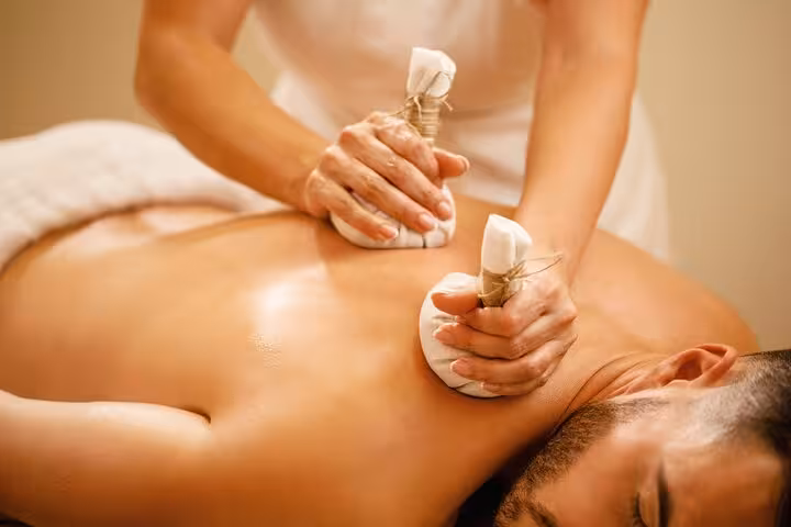 Therapist applying herbal compress massage during 2-hour Hammam spa relaxation in Luxor, Egypt