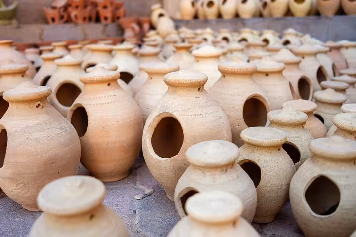 Handcrafted clay pots displayed at a traditional pottery market stop on the Nizwa full-day cultural group tour in Oman