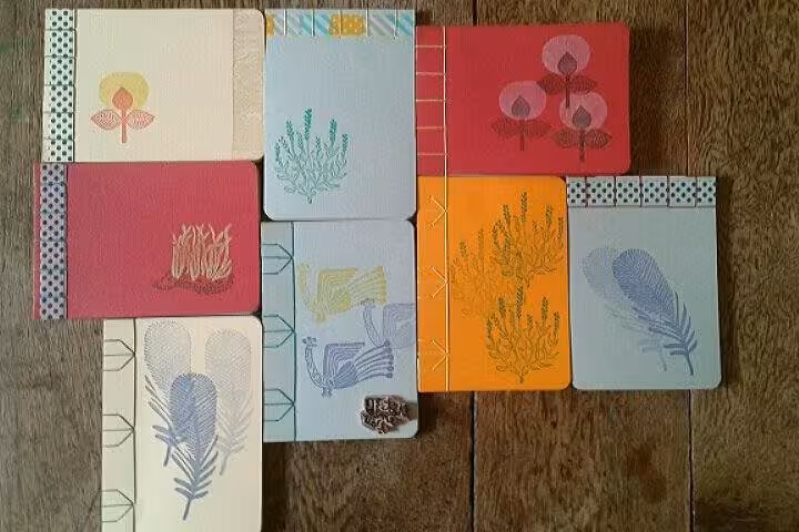 Finished handmade notebooks with botanical covers displayed, created in Marseille Vieux Port bookbinding class