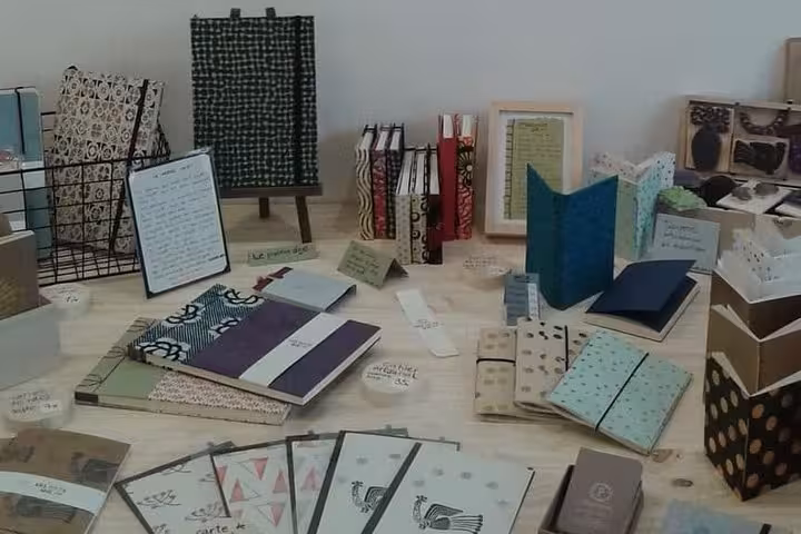 Handmade notebooks and patterned papers displayed at a Marseille Vieux Port bookbinding workshop experience