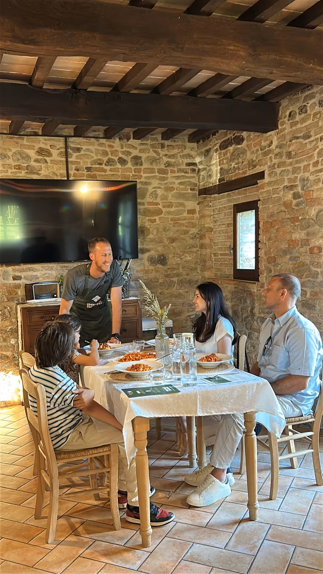 Guests enjoy their handmade pasta tasting with local host in Marche, Italy, at a cozy stone farmhouse dining table