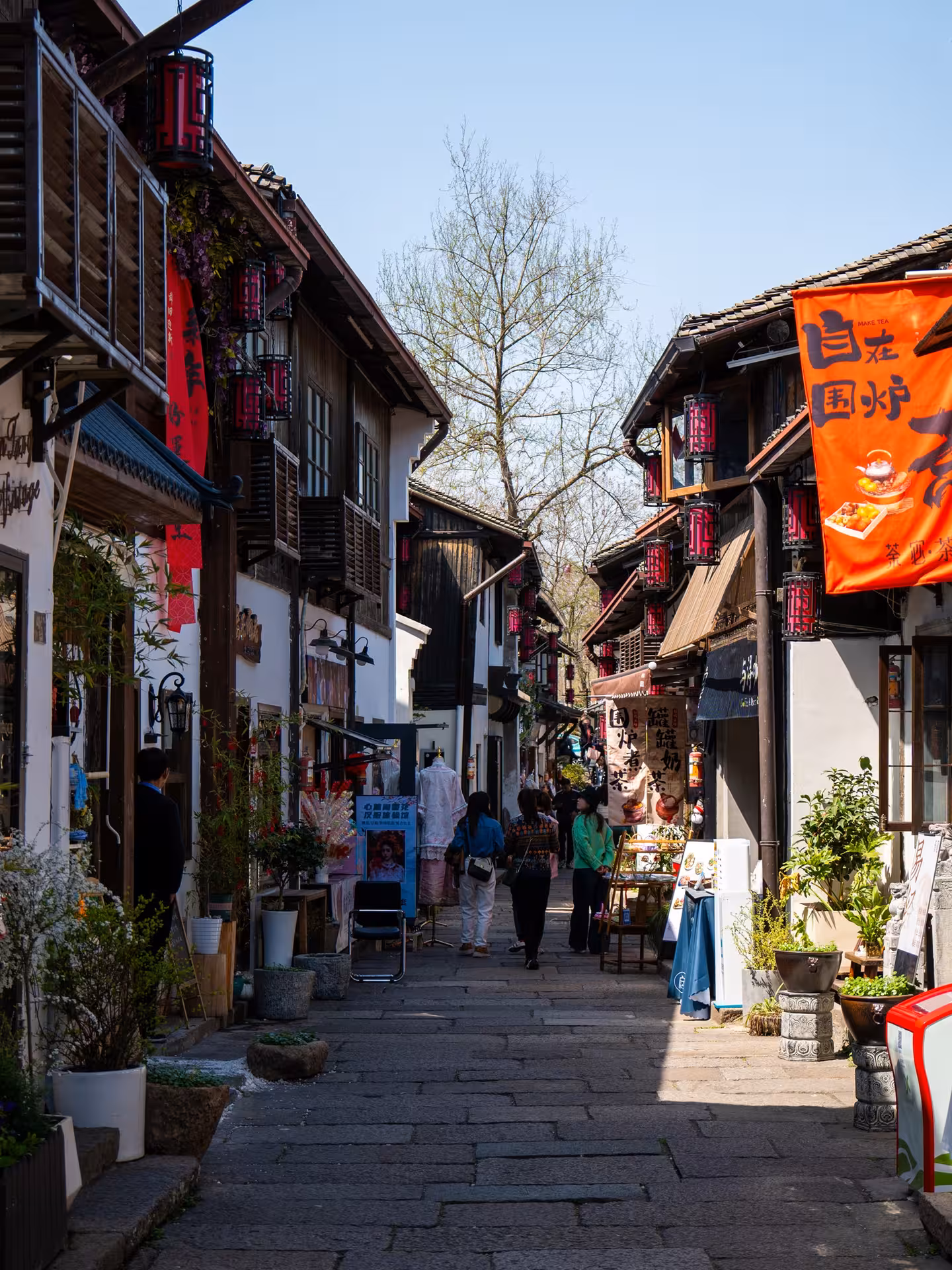 Charming ancient street in Hangzhou with traditional architecture, vibrant shops, and red lanterns, ideal for heritage tours.