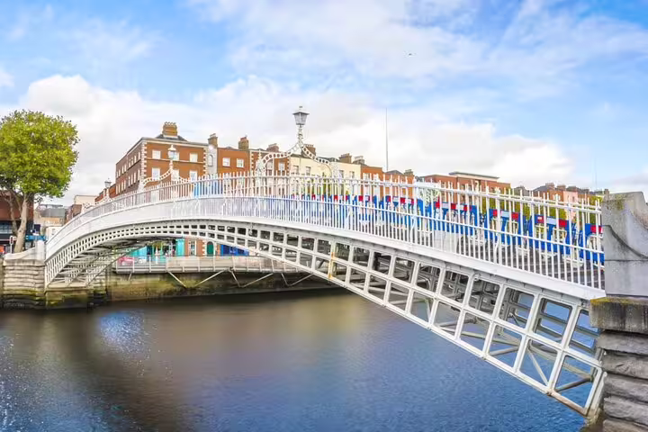 Ha'penny Bridge over the River Liffey in Dublin, with white cast iron railings and colorful flags