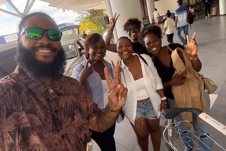 Happy travelers arriving in Seychelles, ready to start their private transfer journey with smiles and excitement.