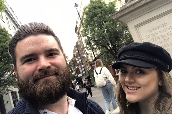 Couple smiling on a London street near a royal monument during a Harry Potter walking tour