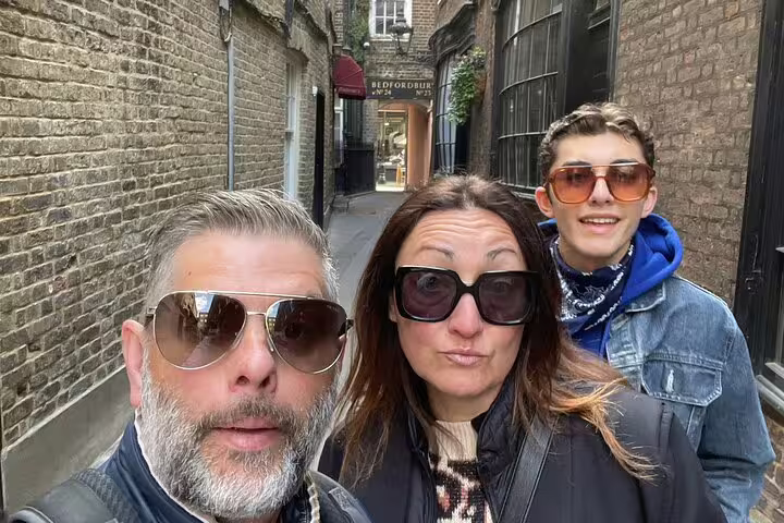 Family of three wearing sunglasses on a narrow London alley during Harry Potter walking tour
