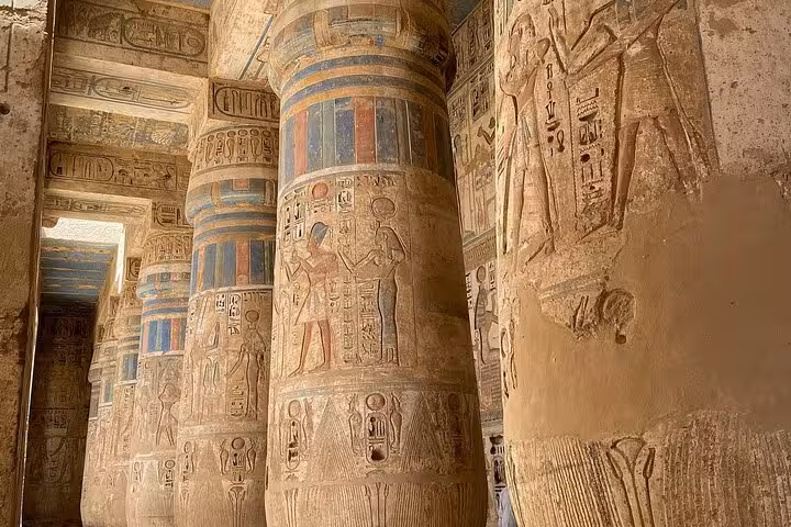 Intricately carved columns with vibrant hieroglyphics at Hatshepsut Temple, part of the Luxor West Bank tour.