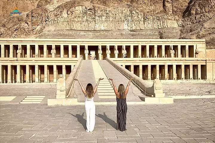 Visitors raising arms at Hatshepsut Temple, highlight of a Luxor full day tour with Karnak and Memnon