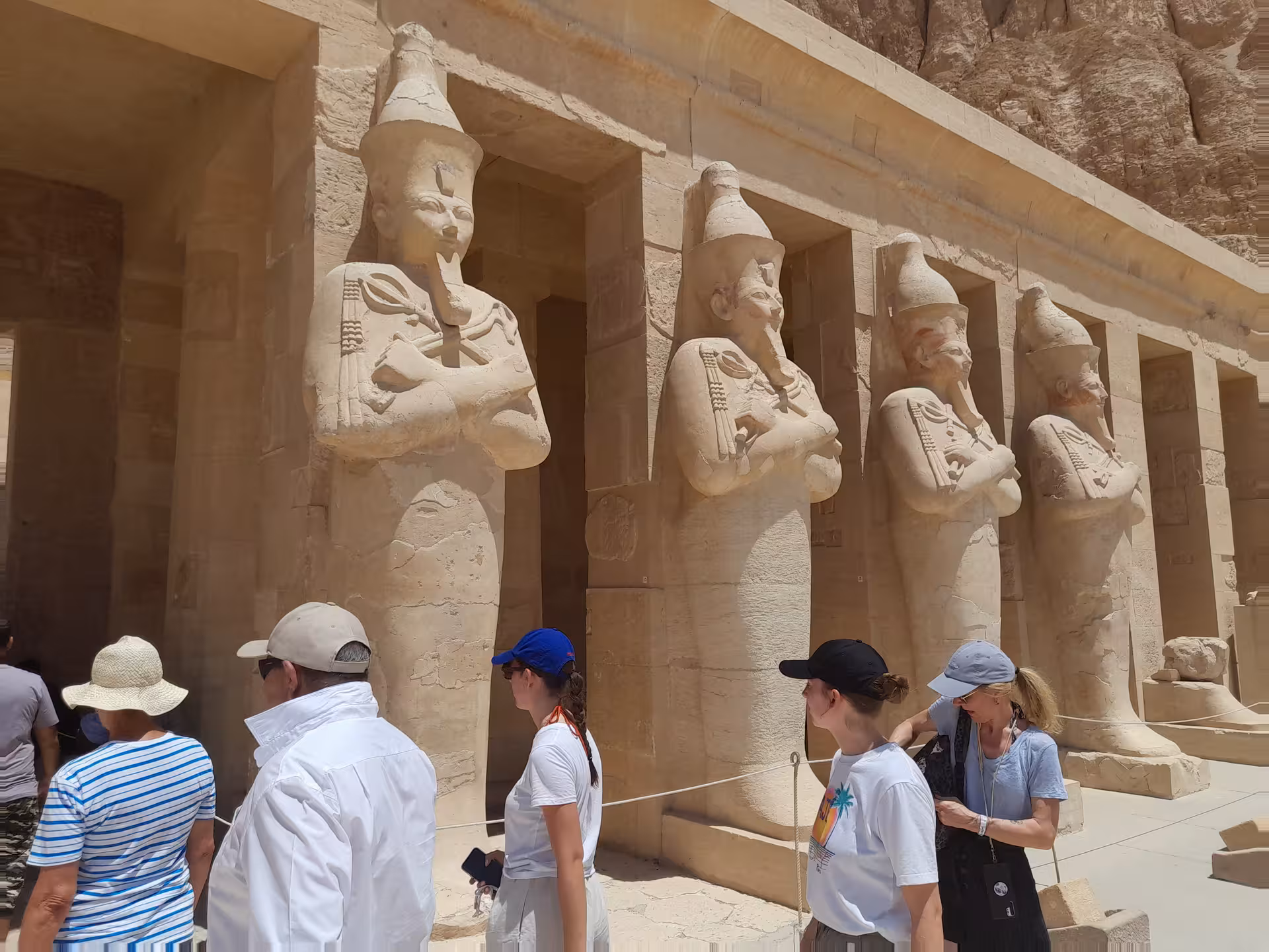 Visitors explore the magnificent statues of Hatshepsut's Temple in the Valley of the Kings, a testament to ancient Egyptian artistry.