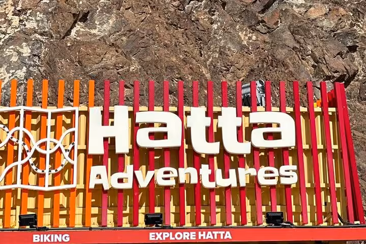Hatta Adventures entrance sign against rocky mountains, highlight stop on a private full-day Hatta tour