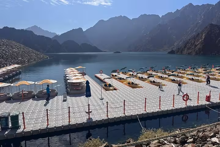 Floating dock with kayaks on Hatta Dam Lake, scenic Hajar Mountains view on full-day private trip