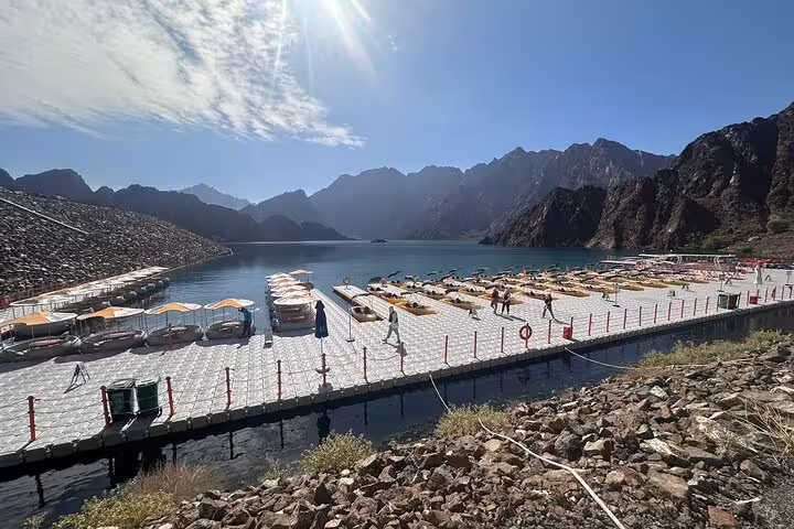 Hatta Dam Lake floating dock with kayaks and mountain views on a private full-day Hatta visit from Dubai
