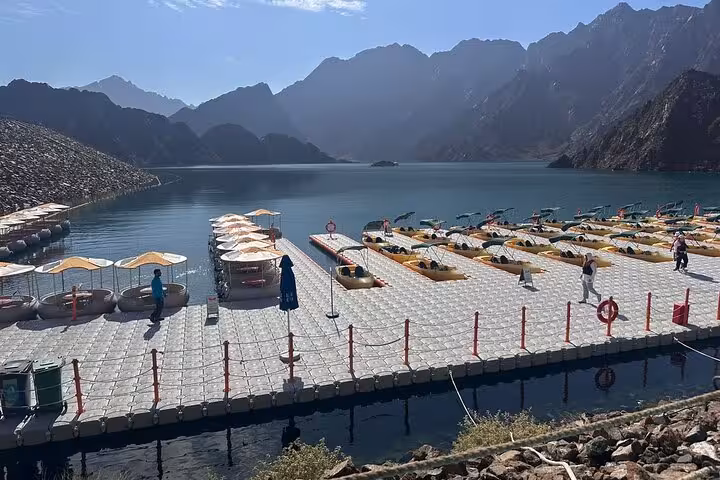 Floating dock with pedal boats at Hatta Dam, scenic mountain views on Hatta City Tour Dam Hills Park private trip