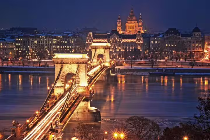 Budapest Chain Bridge illuminated at night with St. Stephen's Basilica glowing in the background