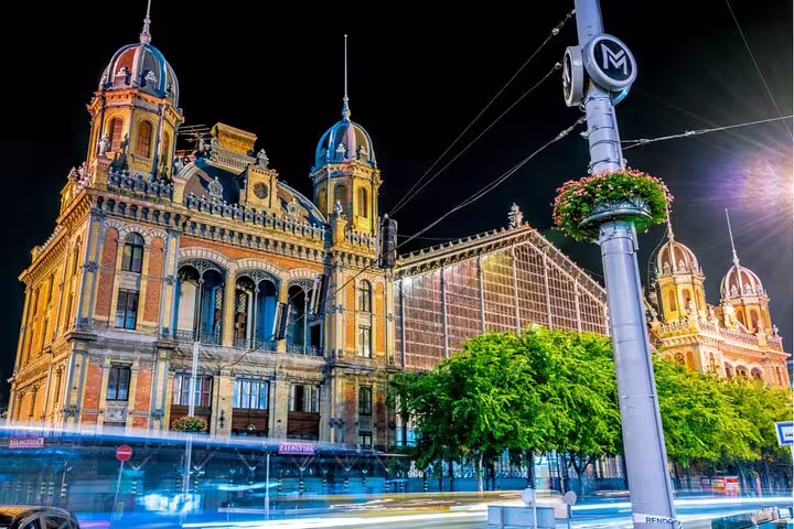 Keleti Railway Station illuminated at night in Budapest, Hungary, with metro sign in foreground