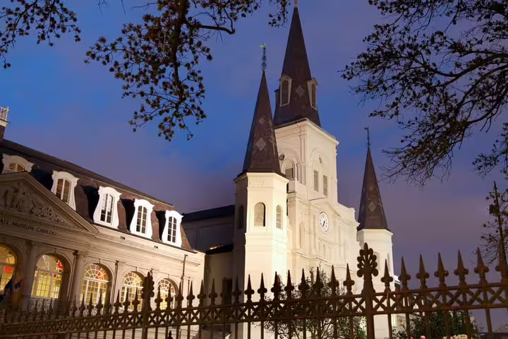 St. Louis Cathedral illuminated at dusk with iron fence in New Orleans French Quarter