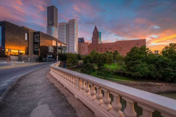 Houston downtown skyline at sunset viewed from a historic bridge with white balustrade railing