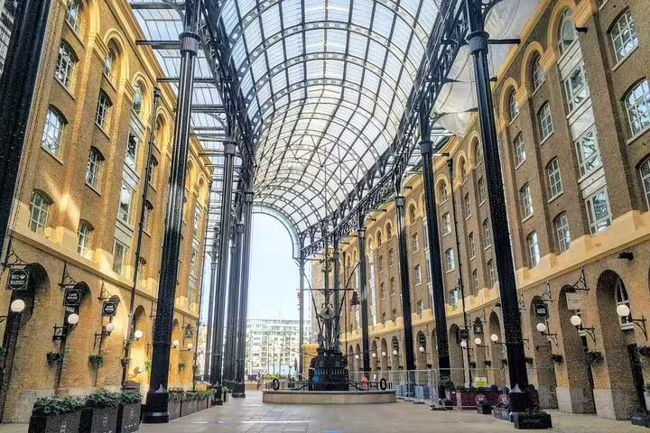 Victorian glass-roofed arcade of Hay's Galleria in Southwark London with tall iron columns