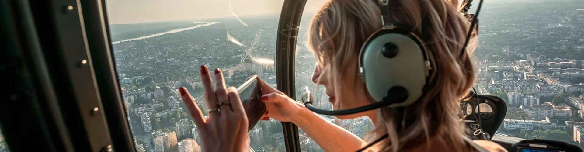 A woman enjoying a breathtaking aerial view from a helicopter, capturing the stunning cityscape below during an exciting air tour adventure.