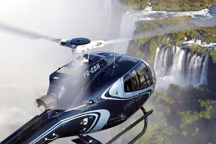 Helicopter flying over Iguazu Falls, offering a stunning aerial view of the cascading waters in Foz do Iguaçu.