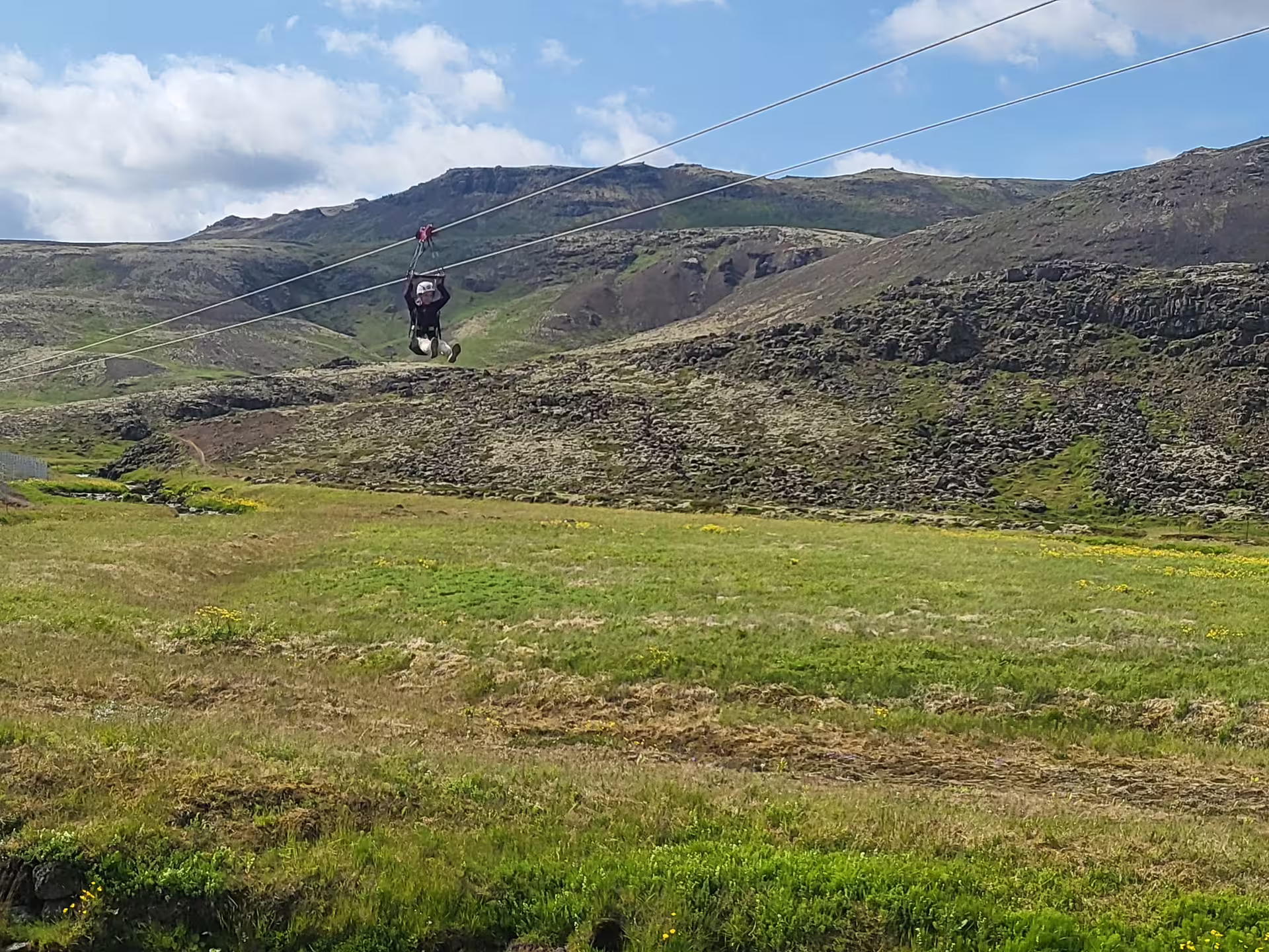 A thrilling zipline adventure over lush landscapes at Hellisheidi Geothermal Exhibition, showcasing Iceland's natural beauty.