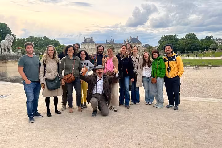 Tour group posing in front of Luxembourg Palace gardens in Paris on a cloudy day