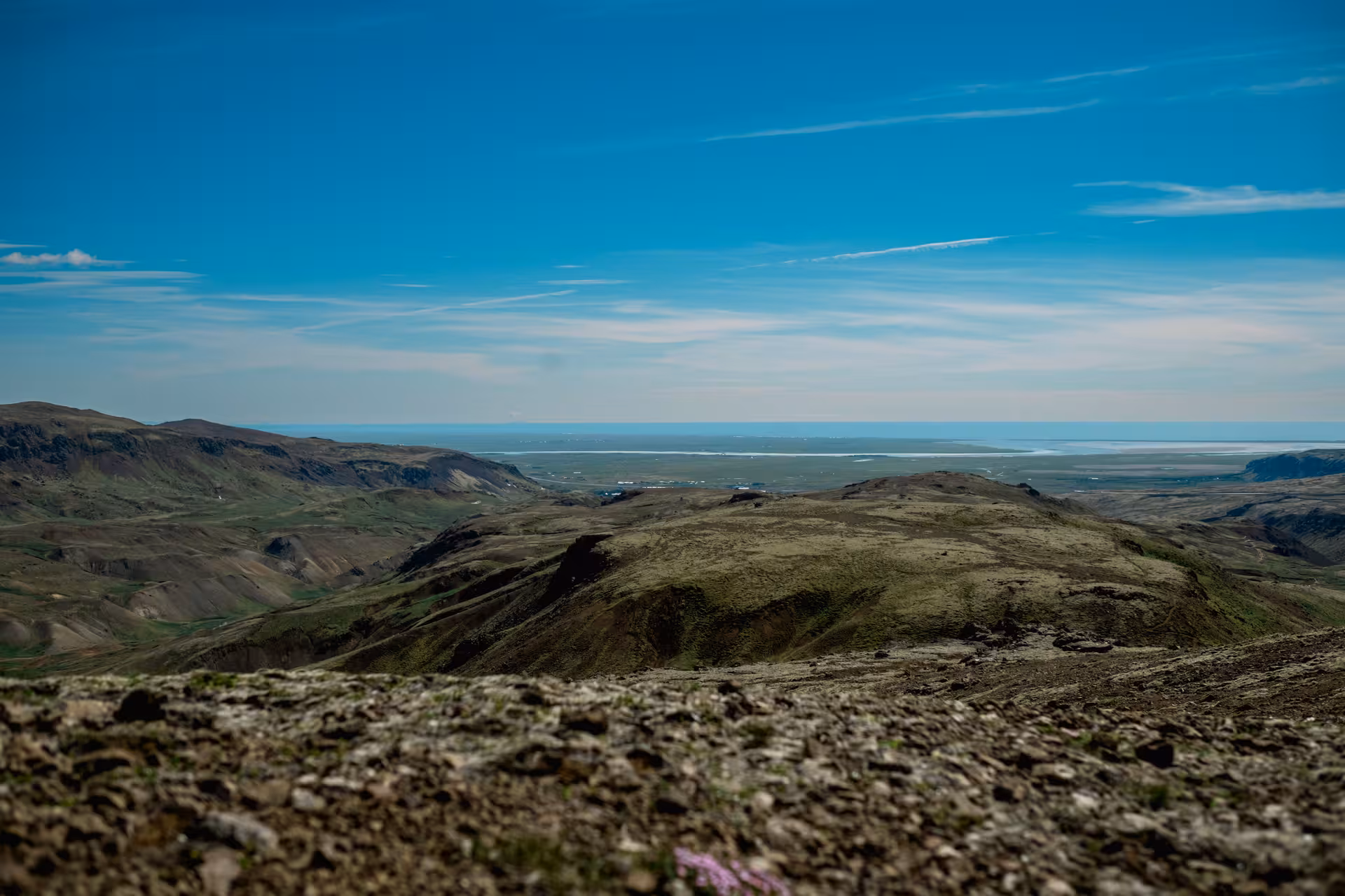 Panoramic view of Iceland's geothermal volcanic highlands near Hengill with coastal plains and blue sky