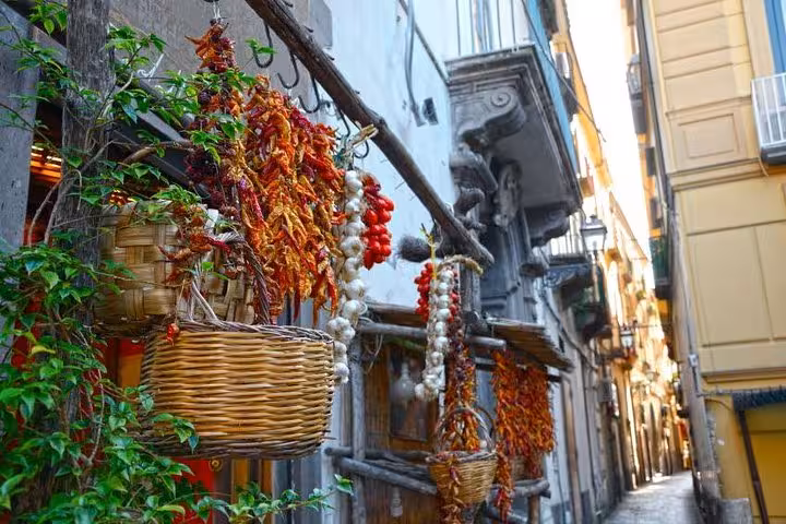 Vibrant display of dried peppers and garlic on a quaint Sorrento street, showcasing local culture on a Hercolaneum tour.