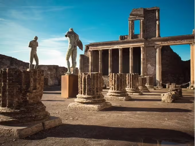 Herculaneum archaeological site columns and statues, guided group tour from Naples with Roman ruins at sunset