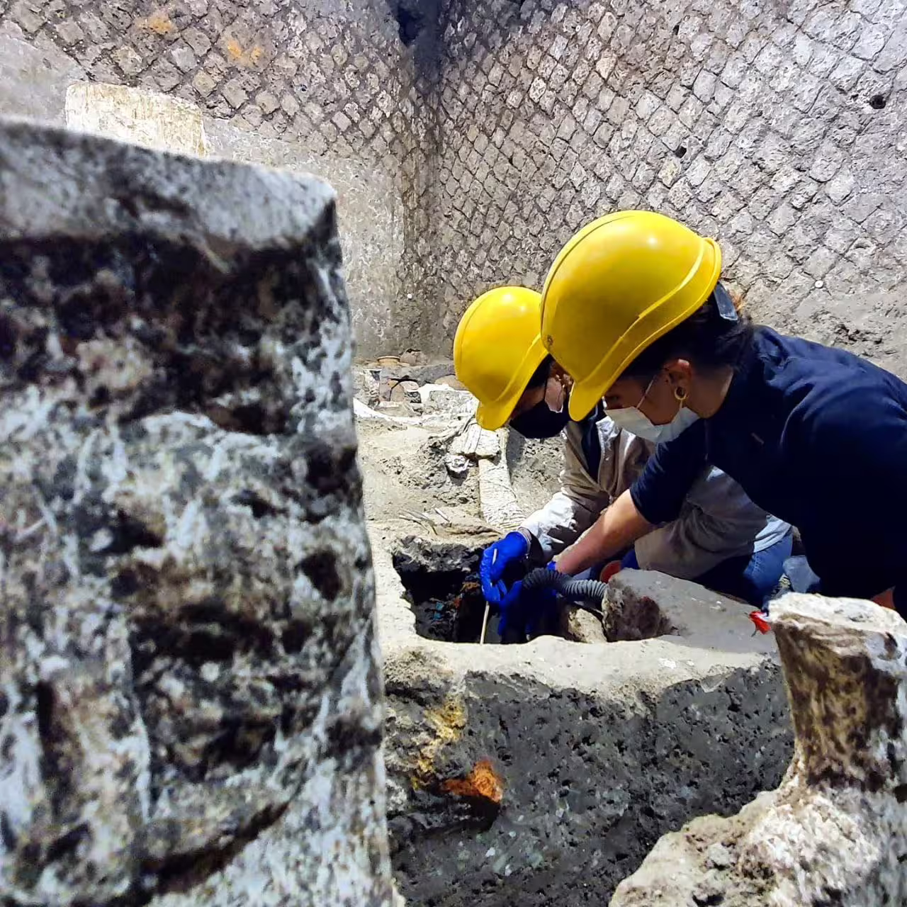Archaeologists at Herculaneum excavation site, a behind-the-scenes moment on Pompeii and Herculaneum group tour from Naples