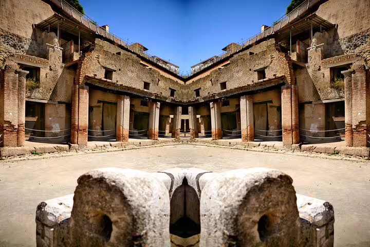 Sunlit courtyard and colonnaded Roman houses in Herculaneum ruins, featured on a personalized private tour with expert guide