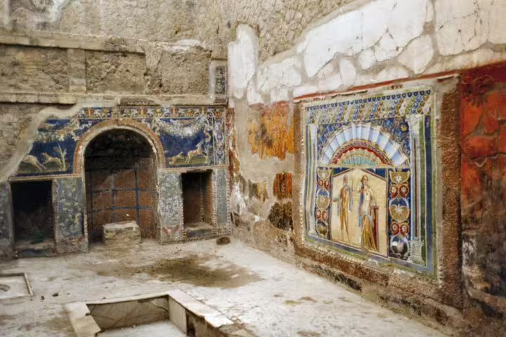 Colorful Roman frescoes inside a Herculaneum house, seen on a low-cost Naples day trip tour